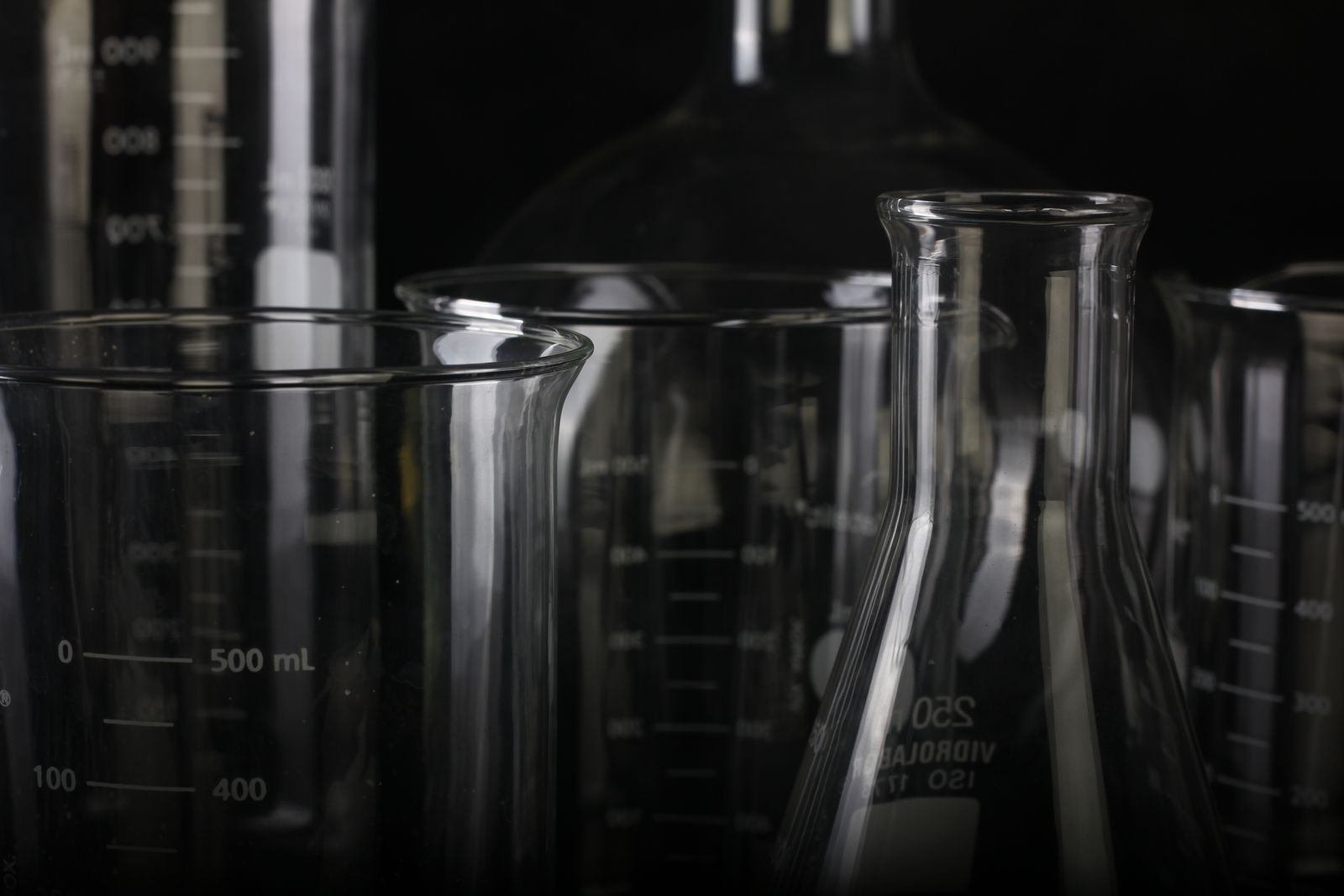 Laboratory beakers and flasks against a dark background
